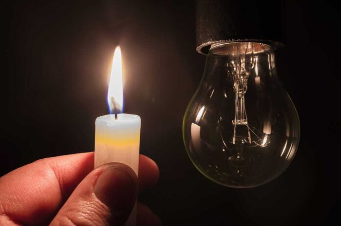 Burning,Candle,Near,A,Switched,Off,Light,Bulb,In,Complete