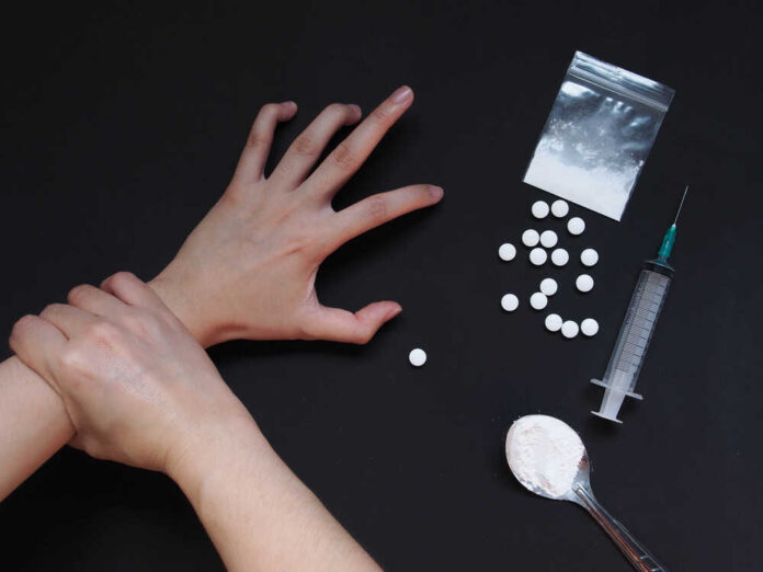 Therapist,Touching,Drug,Addict,Hand,With,Cooked,Heroine,,Syringe,And