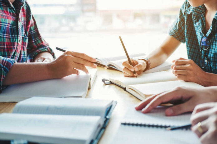 High,School,Or,College,Students,Studying,And,Reading,Together,In