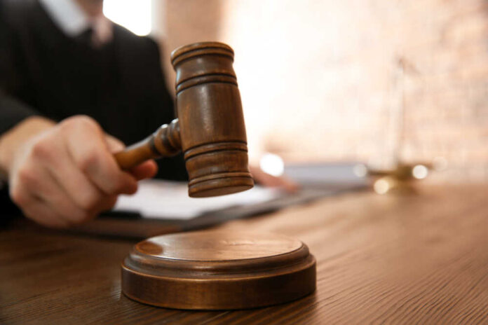 Judge,With,Gavel,At,Table,In,Courtroom,,Closeup.,Law,And