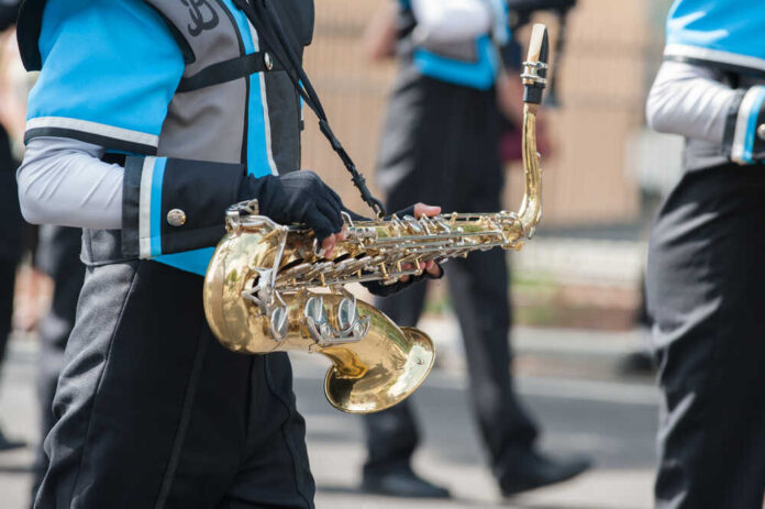 Teen,Saxophone,Player,Marching,In,The,Band.