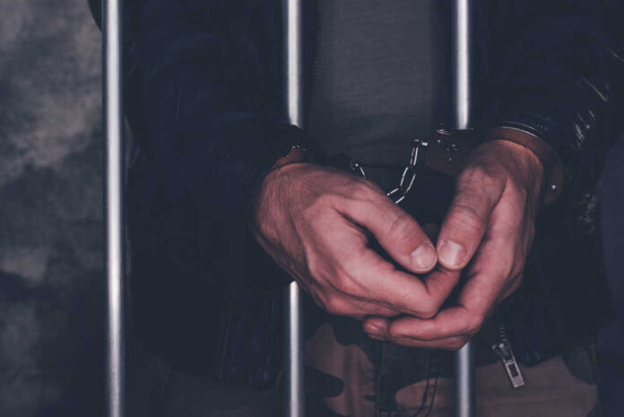 Handcuffed,Man,Behind,Prison,Bars.,Arrested,Criminal,Male,Person,Imprisoned.
