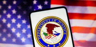 Department of Justice seal on phone, American flag background.