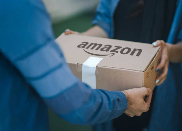 Two people exchanging an Amazon package, outdoors.