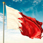 Flag of Bahrain waving against a blue sky