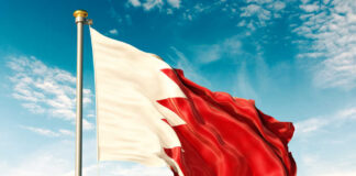Flag of Bahrain waving against a blue sky