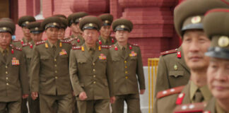 Military officers marching together in uniform.