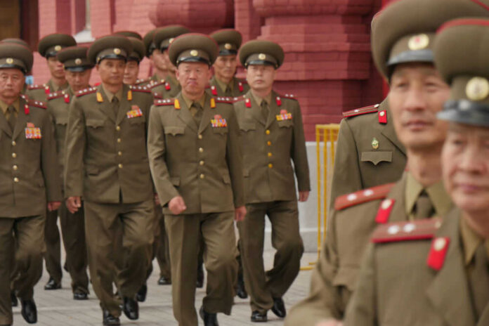 Military officers marching together in uniform.