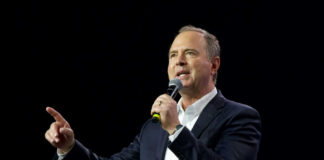 Man speaking into microphone against dark background