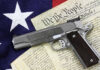 Pistol on Constitution and flag background.