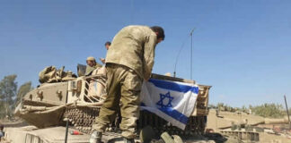 Soldiers setting Israeli flag on military vehicle tank