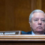 Man sitting at a desk with nameplate Sen Graham