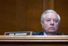 Man sitting at a desk with nameplate Sen Graham