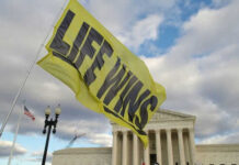 Yellow flag with life wins near courthouse building