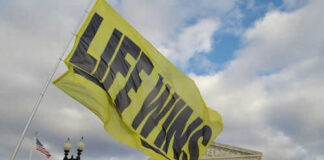 Yellow flag with life wins near courthouse building