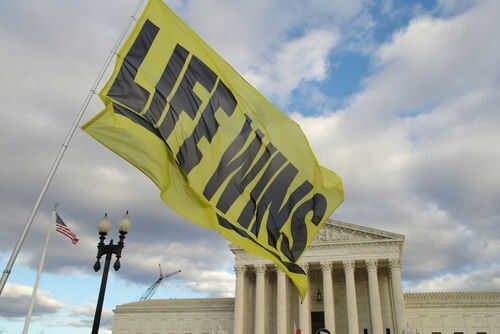 Yellow flag with life wins near courthouse building