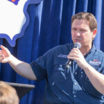 Person speaking into microphone during public event