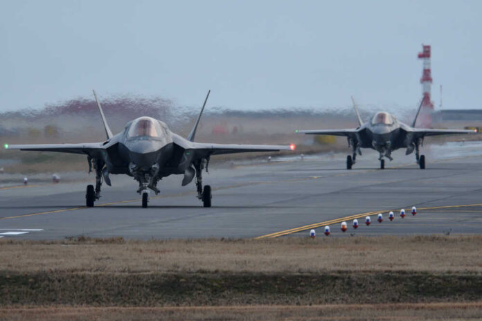 shutterstock_1296104293.jpg Two F-35 fighter jets on an airfield preparing for takeoff