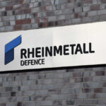 Sign displaying Rheinmetall Defence logo on a brick wall