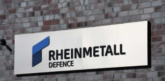 Sign displaying Rheinmetall Defence logo on a brick wall