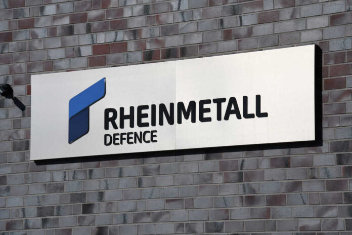 Sign displaying Rheinmetall Defence logo on a brick wall