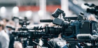 Row of cameras set up for a press event