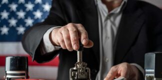 A person stamping passports on a desk with various stamps and documents