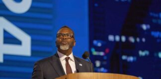 A business leader speaking at a podium during a conference