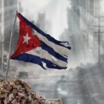 Worn Cuban flag standing on rubble in a desolate urban environment