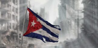 Worn Cuban flag standing on rubble in a desolate urban environment