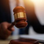 A gavel being struck on a desk in a courtroom setting
