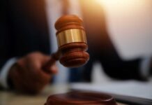 A gavel being struck on a desk in a courtroom setting