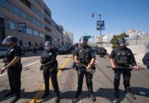 Riot Revelations: Police Guard Protesters Police officers in riot gear standing on a street during a protest