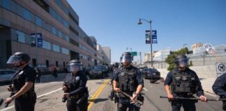 Police officers in riot gear standing on a street during a protest