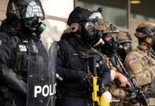 DHS Leaders Blocked Probes: Shocking Watchdog Claims Police officers in tactical gear and gas masks standing in formation