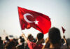 Person waving Turkish flag in a crowd