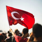 Person waving Turkish flag in a crowd