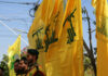 Men standing with yellow flags wearing green berets