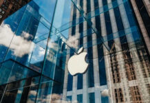 Apple store glass building with cloudy sky reflection