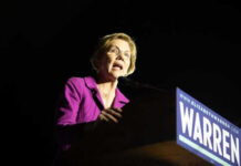 Warren’s Tax Plan – Billionaires Brace for Impact Woman speaking at a podium with microphone.