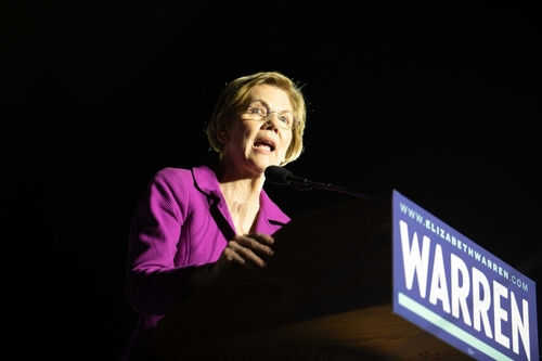 Woman speaking at a podium with microphone.