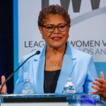 Mayor’s Pledge Falls Flat: LA’s Ongoing Street Turmoil Woman speaking at a podium in blue jacket