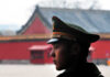 A military guard in uniform standing in profile against a historical building