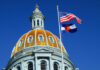 Supreme Court Slam: Colorado’s Costly Losses The dome of a state capitol building with flags flying against a blue sky