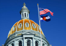 Supreme Court Slam: Colorado’s Costly Losses The dome of a state capitol building with flags flying against a blue sky