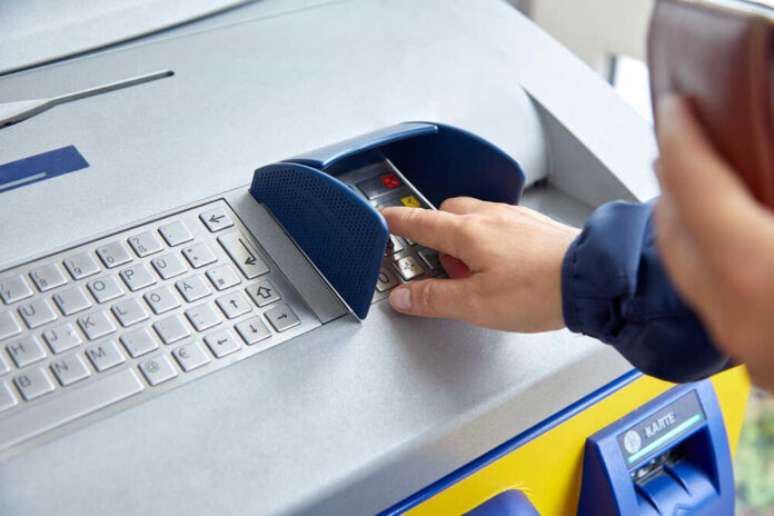Person using an ATM keypad to perform a transaction
