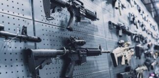 A wall displaying various firearms in a gun shop