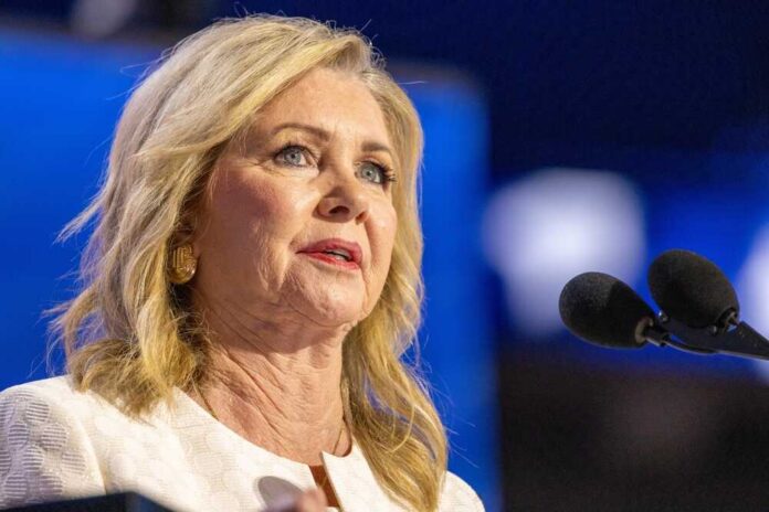 A woman speaking at a podium with microphones in front of her