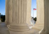 View of marble columns with an American flag in the background