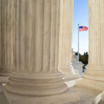 View of marble columns with an American flag in the background